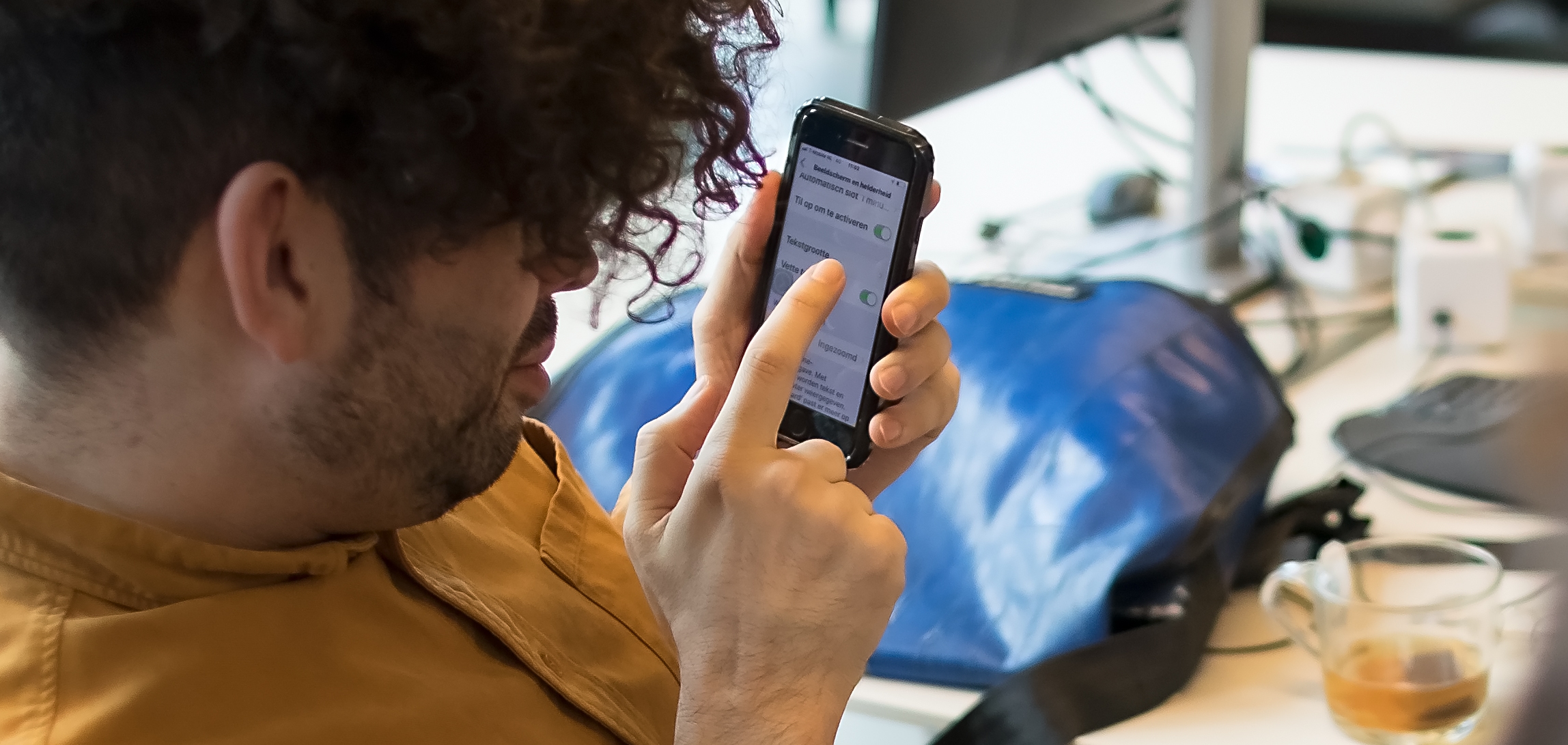 A man interacting with his phone. The screen is zoomed in.